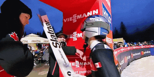 a person holding a skis that says slatnar on it