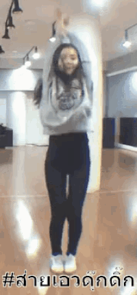 a young girl is jumping in the air in a dance studio .