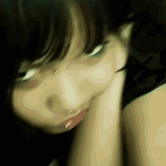 a close up of a woman 's face with her hand on her face