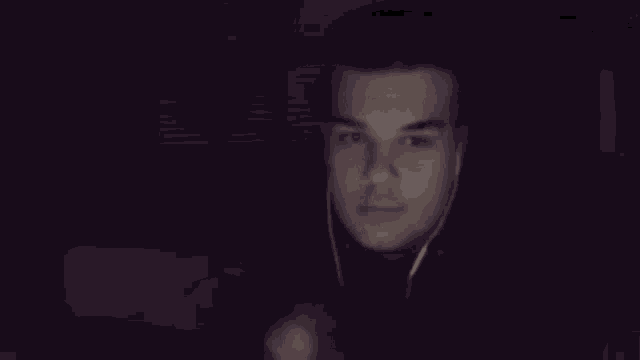 a blurry picture of a man wearing headphones and looking at a computer screen .