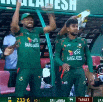 two bangladesh players are standing in front of a sign that says ' bangladesh ' on it