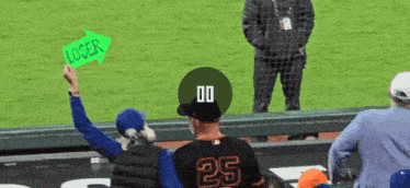 a man wearing a number 25 jersey holds up a sign that says loser