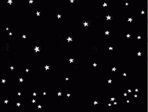 a bunch of white stars are falling in the night sky .