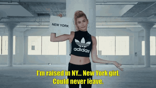 a woman holding a sign that says i 'm raised in ny new york girl