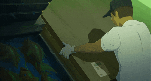 a man in a baseball cap is reaching for a box