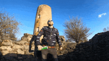 a man standing in front of a stone tower with the number 7 on the top