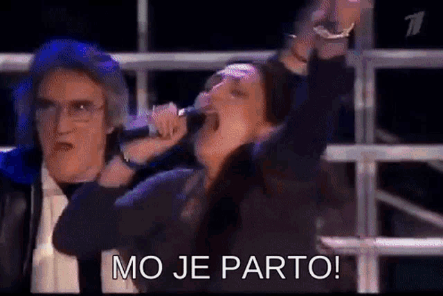 a woman singing into a microphone with a man behind her and the words mo je parto on the bottom
