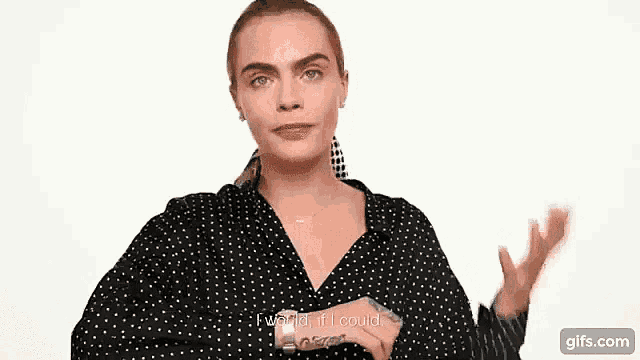 a woman in a black and white polka dot shirt is talking to the camera .