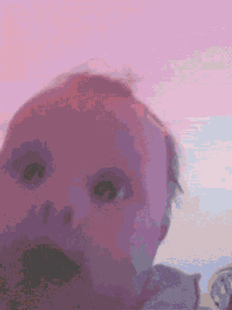 a pixelated image of a baby looking at the camera