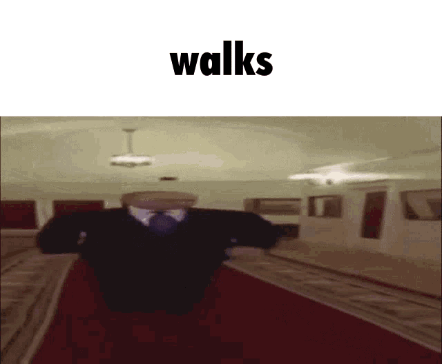 a man in a suit and tie walks down a red carpet .