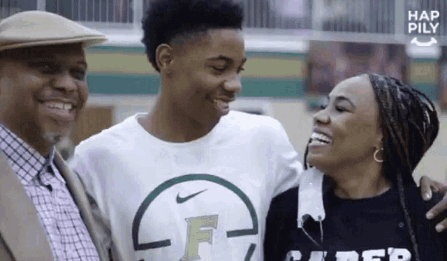 a man and a woman are posing for a picture with a boy in a basketball uniform .