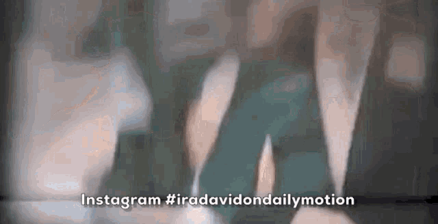 a close up of a person holding a cell phone with the words `` instagram #iradavidondailymotion '' written on it .