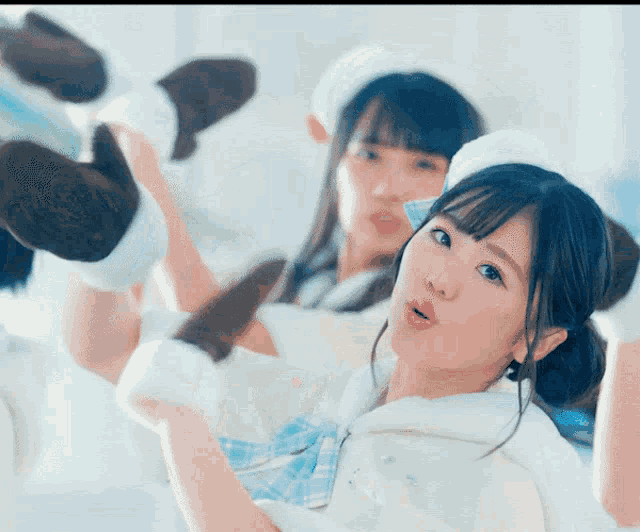 a girl with a surprised look on her face is standing next to another girl wearing slippers
