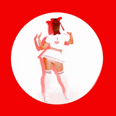 a woman in a white top and shorts is dancing in a red circle