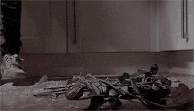 a person 's feet are hanging over a pile of flowers on the floor