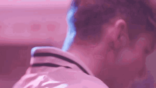 a close up of a man 's neck and shoulder in a purple light .
