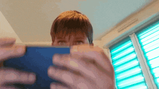 a person is holding a tablet in front of a window