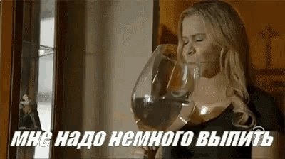 a woman is drinking from a large wine glass in a foreign language