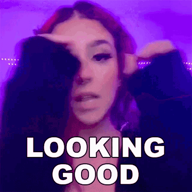 a woman with red hair is covering her face with her hand and the words `` looking good '' written above her .