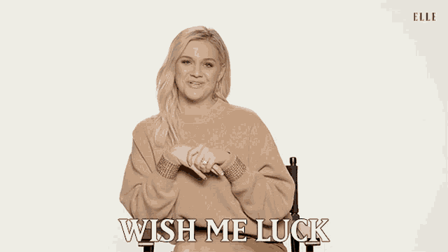 a woman sitting in a chair with the words wish me luck above her