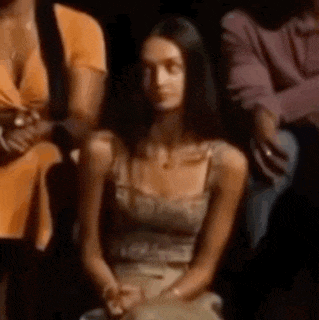 a woman is sitting in a crowd of people .