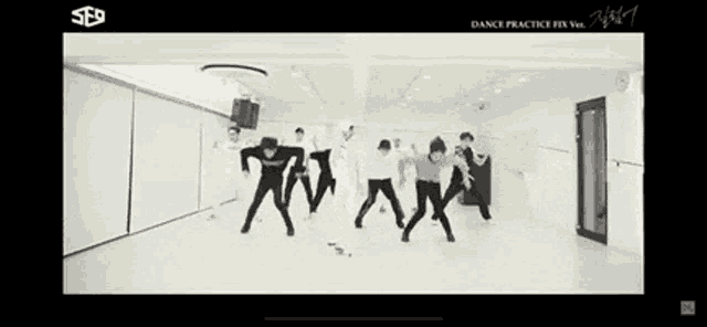a group of people are dancing together in a white room .