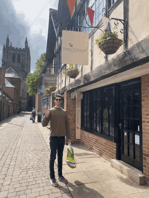 a man holds a bag in front of a building that says hey honey
