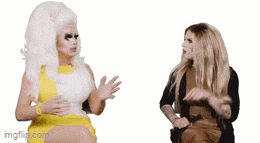 a drag queen in a yellow dress is talking to another drag queen in a brown dress