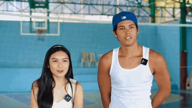 a man and a woman are standing next to each other in front of a volleyball net with the word ara on it