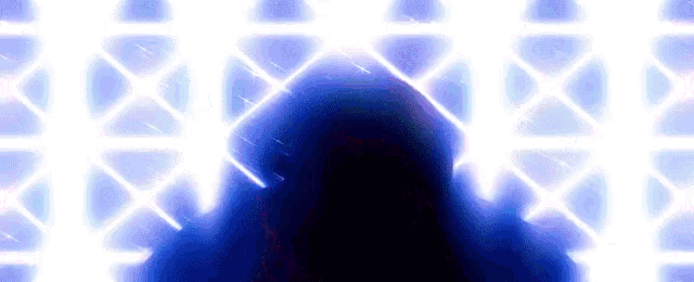 a silhouette of a person standing in front of a blue light