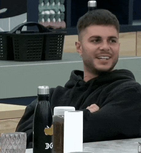 a man sits at a table with a bottle that says dg