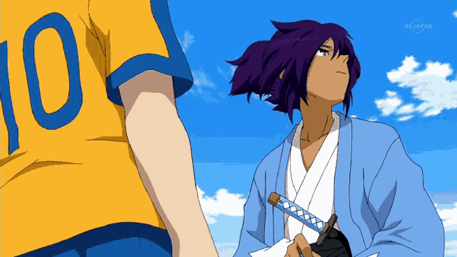 a man in a yellow shirt with the number 10 on it stands next to a man in a blue kimono