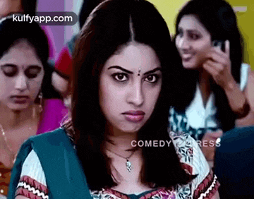 a woman is making a funny face in front of a crowd of people .