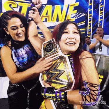 two female wrestlers are posing for a picture in front of a banner that says ' slane '