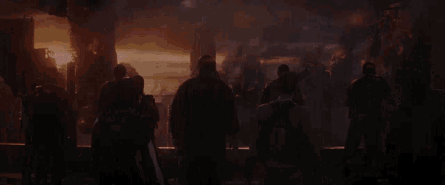 a group of people standing in front of a sunset