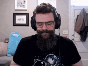 a man with a beard wearing headphones and a cat shirt