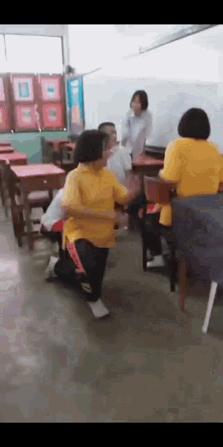 a group of people are dancing in a classroom while sitting at their desks .