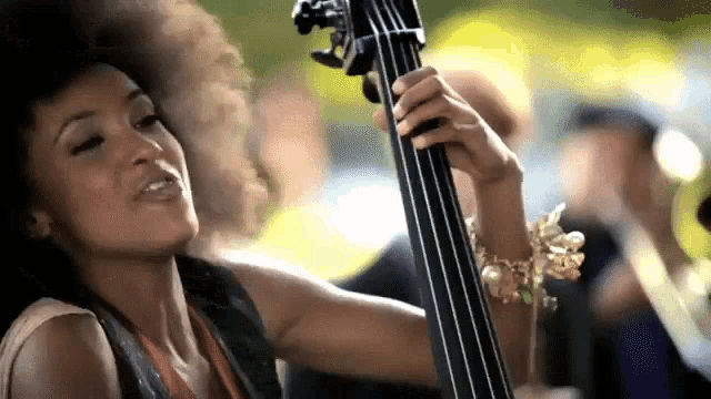 a woman with a bracelet on her wrist is playing a bass