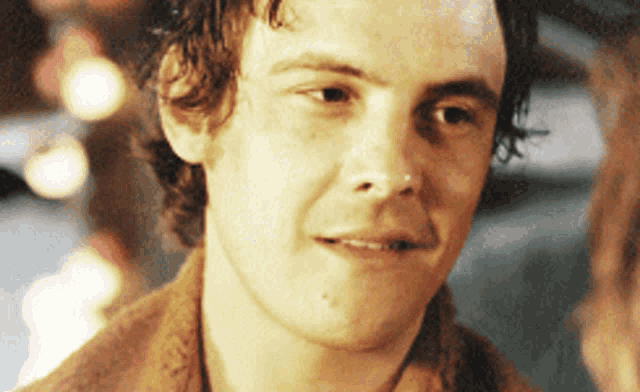 a close up of a young man 's face with a blurred background