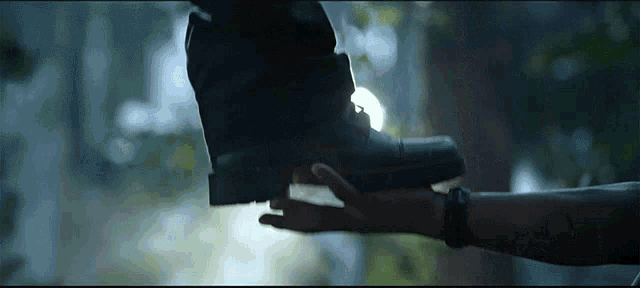 a close up of a person 's hand reaching out towards another person 's foot