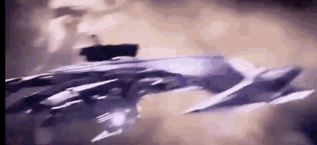 a close up of a jet flying through the air in a dark room .