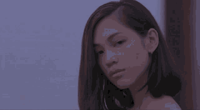 a close up of a woman 's face with a purple sky in the background