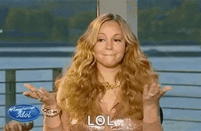 a woman is making a funny face with her hands outstretched and the word lol written on her face .