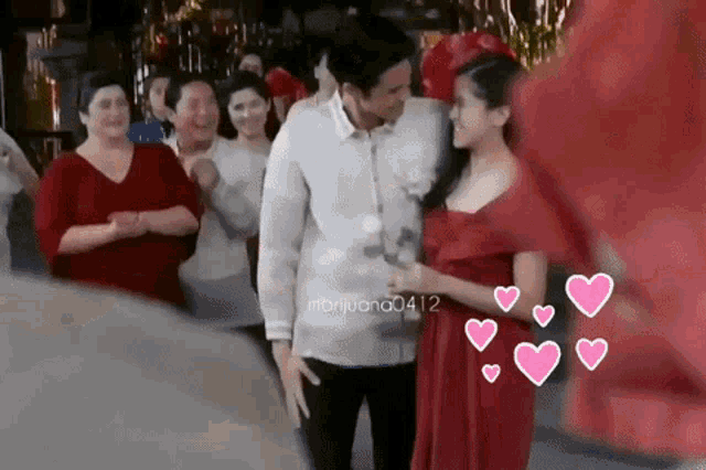 a man and woman are standing next to each other in front of a crowd .