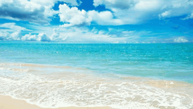 a beach with a blue sky and white clouds and waves crashing on the sand