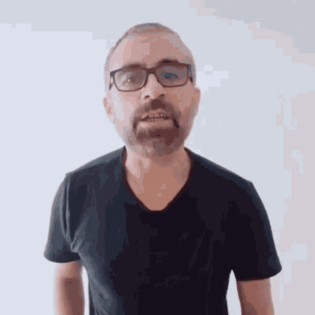 a man with glasses and a beard wearing a black shirt