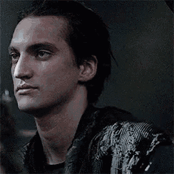a close up of a man 's face in a dark room looking at the camera .
