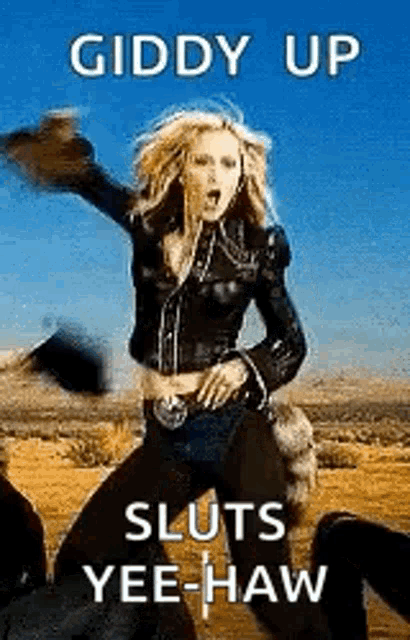 a woman in a leather jacket is dancing in the desert with a cowboy hat .