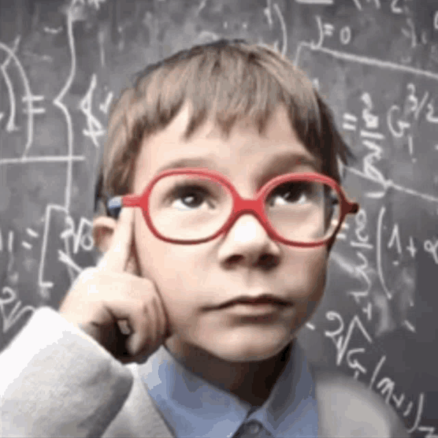 a young boy wearing red glasses is thinking in front of a blackboard with math equations on it