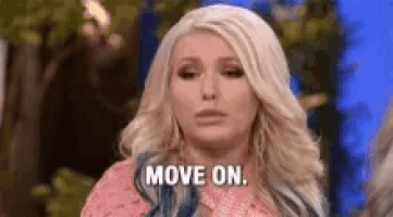 a woman is saying `` move on '' while standing in front of a crowd .